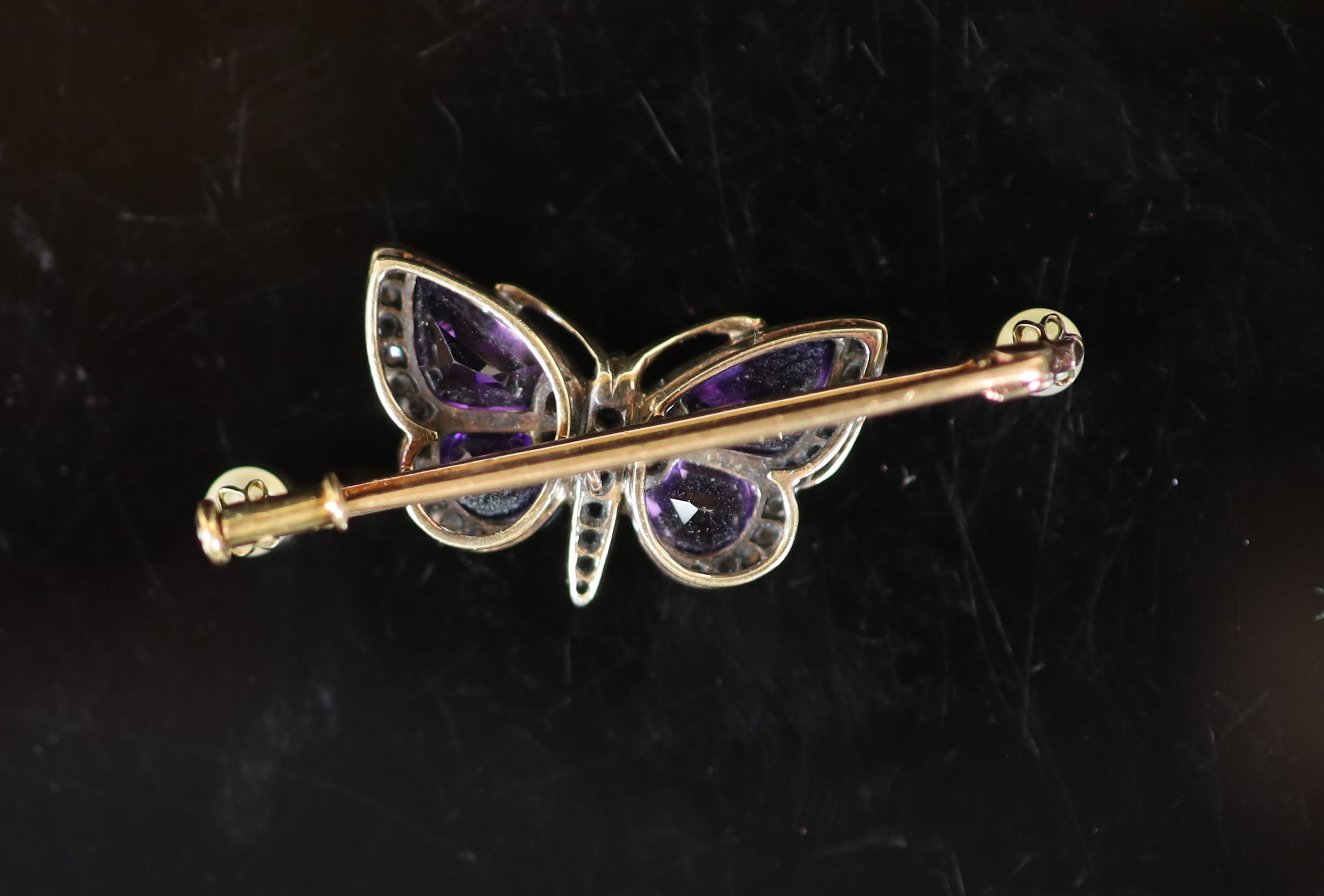 An early 20th century gold, shaped amethyst, rose cut diamond and two stone pearl set butterfly bar brooch